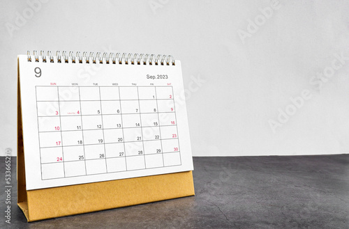 month September 2023 desk calendar for planners and reminders on a black table on a white background.