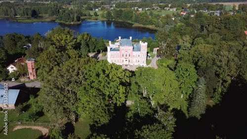 Aerial View of the Birinu Palace. Latvian Castle by Lake With Nice Garden, Drone Shot. Birini Manor, Vidzeme Region, Latvia. Sunny Autumn Day photo