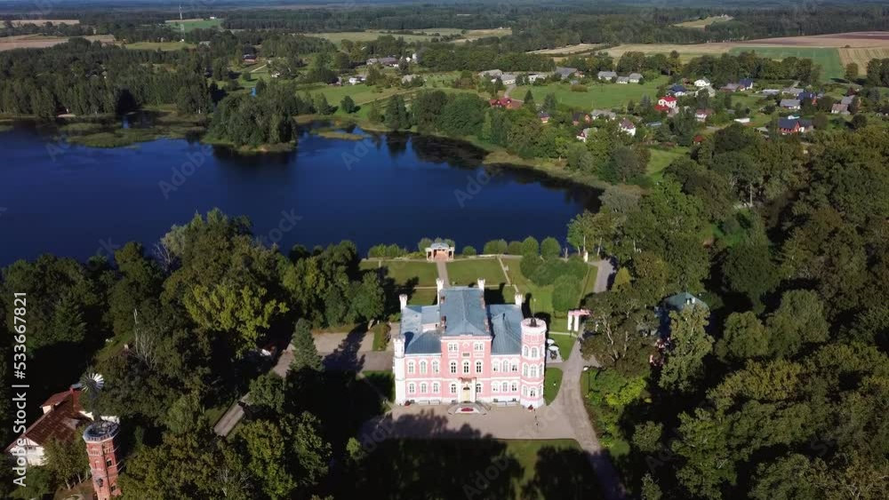 Aerial View of the Birinu Palace. Latvian Castle by Lake With Nice Garden, Drone Shot. Birini Manor, Vidzeme Region, Latvia. Sunny Autumn Day Aerial View of the Birinu Palace. Latvian Castle by Lake With Nice Garden, Drone Shot. Birini Manor, Vidzeme Region, Latvia. Sunny Autumn Day