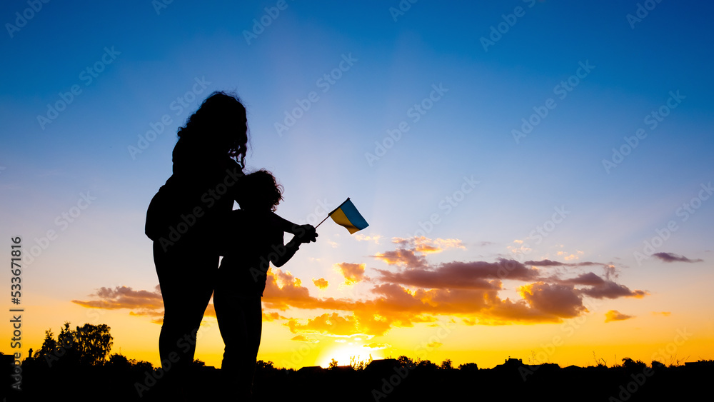 mother with a child against the background of a blue yellow sunset sky with the flag of ukraine in hand, Ukrainian victory in the war