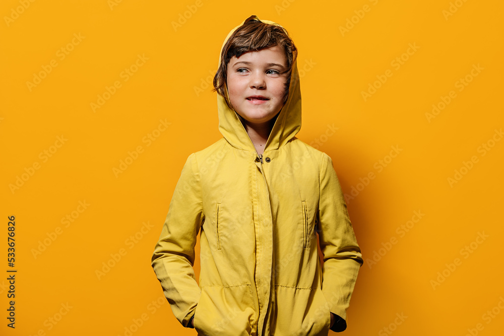 Girl looking at camera against yellow wall in studio Girl looking at camera against yellow wall in studio