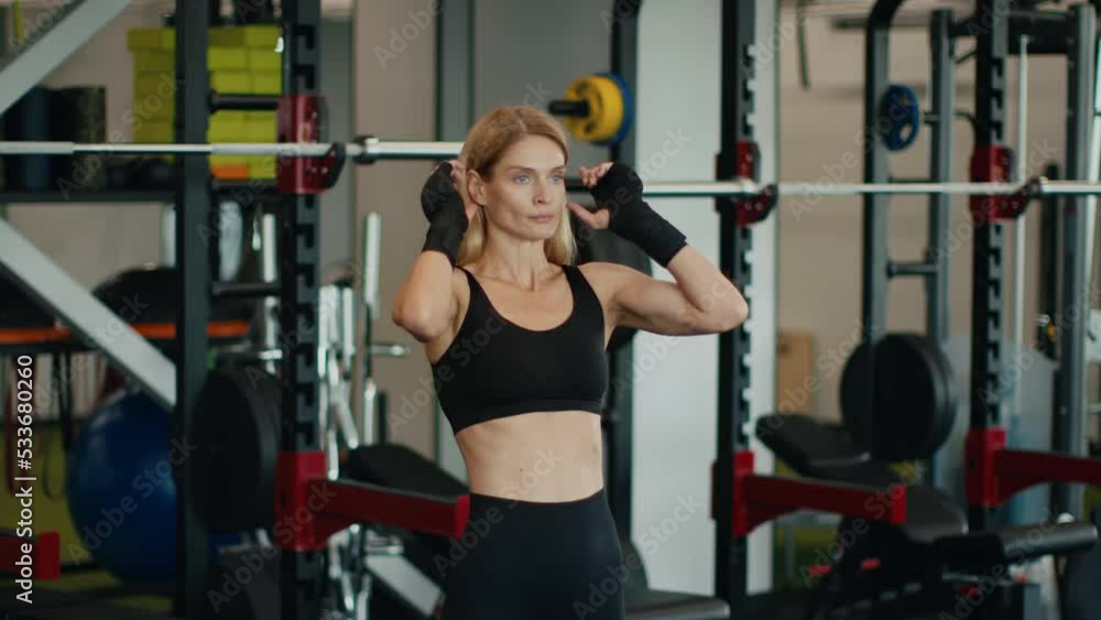 Active middle aged woman athlete in sport suit fixing her hair, enjoying result of workout at gym, free space Active middle aged woman athlete in sport suit fixing her hair, enjoying result of workout at gym, free space