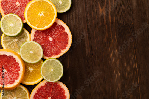 Tropical fruits cut into slices on a wooden background with copy space . Top view.