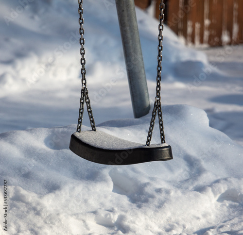 Children's swing in the snow in the park.