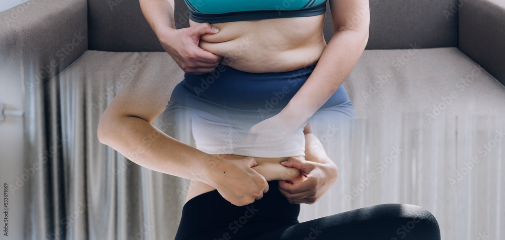 Fototapeta premium Beautiful fat woman with tape measure She uses her hand to squeeze the excess fat that is isolated on a white background. She wants to lose weight, the concept of surgery and break down fat under the
