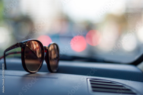 sunglasses on car deck with city reflection