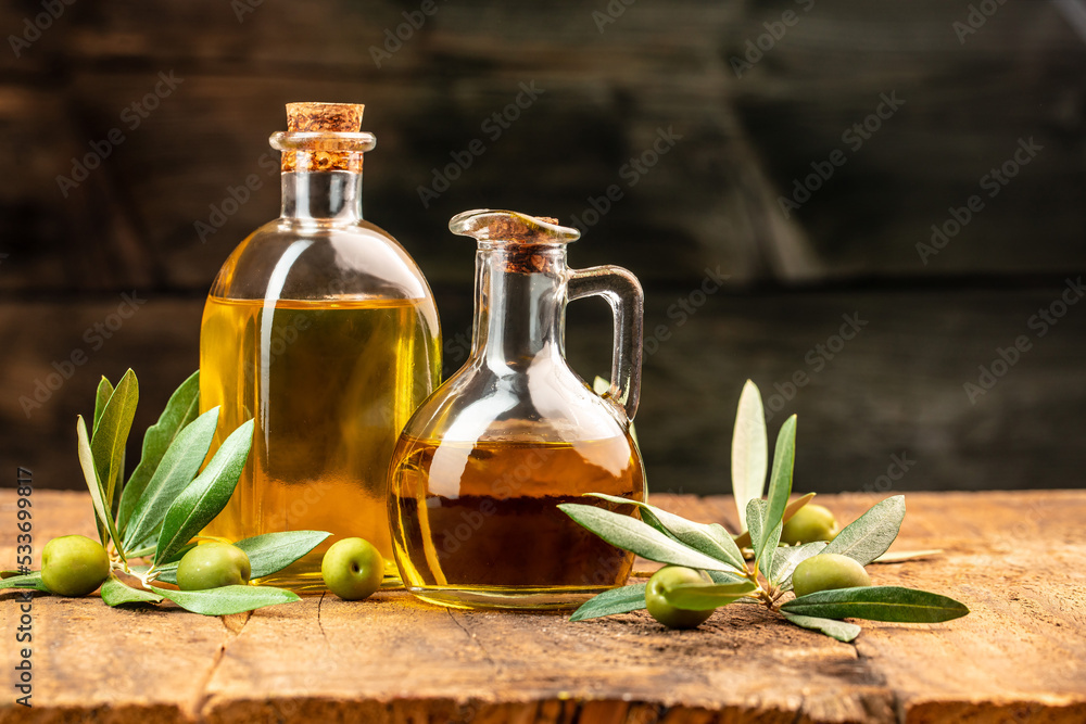 green olives with olive oil. extra virgin olive oil jars on a wooden background. place for text green olives with olive oil. extra virgin olive oil jars on a wooden background. place for text
