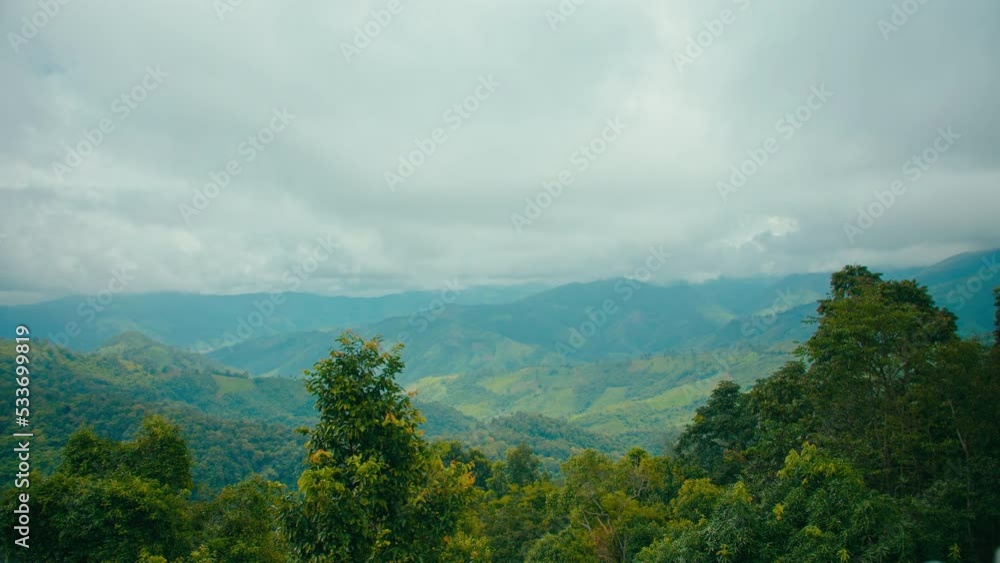 Time lapse of moving clouds layers and rain with fresh green mountain valley view