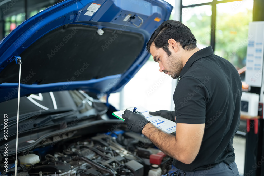 Mechanic Asian Arab man close up using laptop computer and diagnostic software to tuning fixing repairing car engine automobile vehicle parts using tools equipment in workshop garage support services Mechanic Asian Arab man close up using laptop computer and diagnostic software to tuning fixing repairing car engine automobile vehicle parts using tools equipment in workshop garage support services