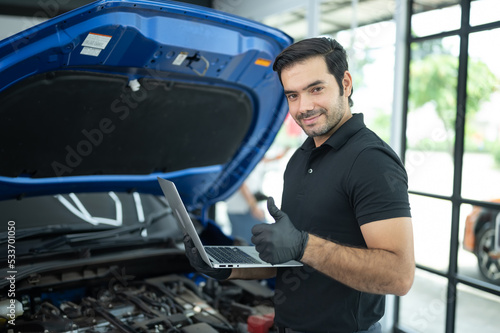 Mechanic Asian man close up using laptop computer and diagnostic software to tuning fixing repairing car engine automobile vehicle parts using tools equipment in workshop garage support service