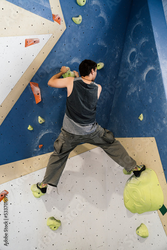 Young boy climbing a wall in an indoor climbing wall