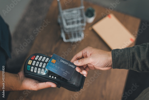 Fototapeta Naklejka Na Ścianę i Meble -  Customer using credit card for payment to owner at cafe restaurant, cashless technology and credit card payment concept