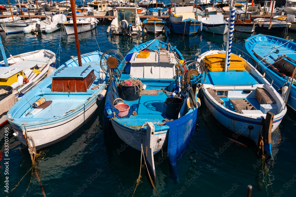 Colorful wooden fisher boats in the harbour Marina Grande on Capri Island Italy. Blue and yellow colors dominatie the port which starting point for tours to the Blue Cave, Naples or Amalfi coast.