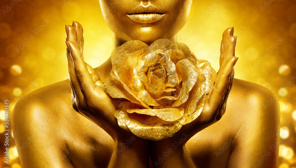 Fotka „Gold Skin Woman Face. Golden Lips Make up with Flower close up.  Female Hand Palms Holding Jewellery Rose over Shining Fantasy Background.  Luxury Beauty Spa. Gold Metallic Bodyart“ ze služby Stock