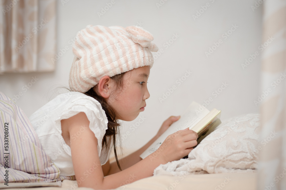ベッドで本を読む少女 ベッドで本を読む少女