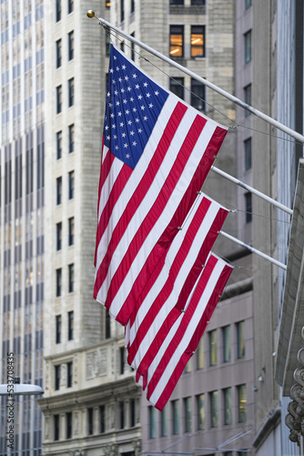 A lot of American flags for United States of America are hanged in the financial district from Wall Street in New York City