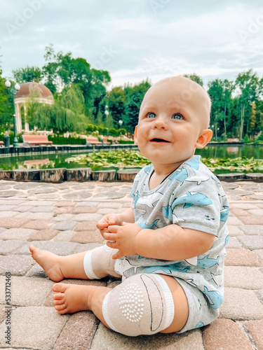 Closeup cute baby boy sitting in the park summer time