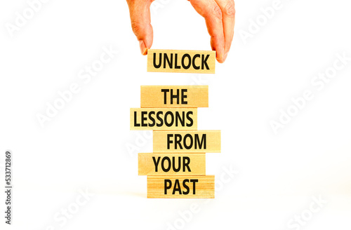 Lessons from your past symbol. Concept words Unlock the lessons from your past on wooden blocks. Bussinesman hand. Beautiful white background. Business and lessons from your past concept. Copy space.