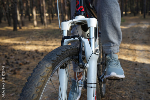 Mountain biking. Cyclist riding a mountain bike in the forest, close-up.