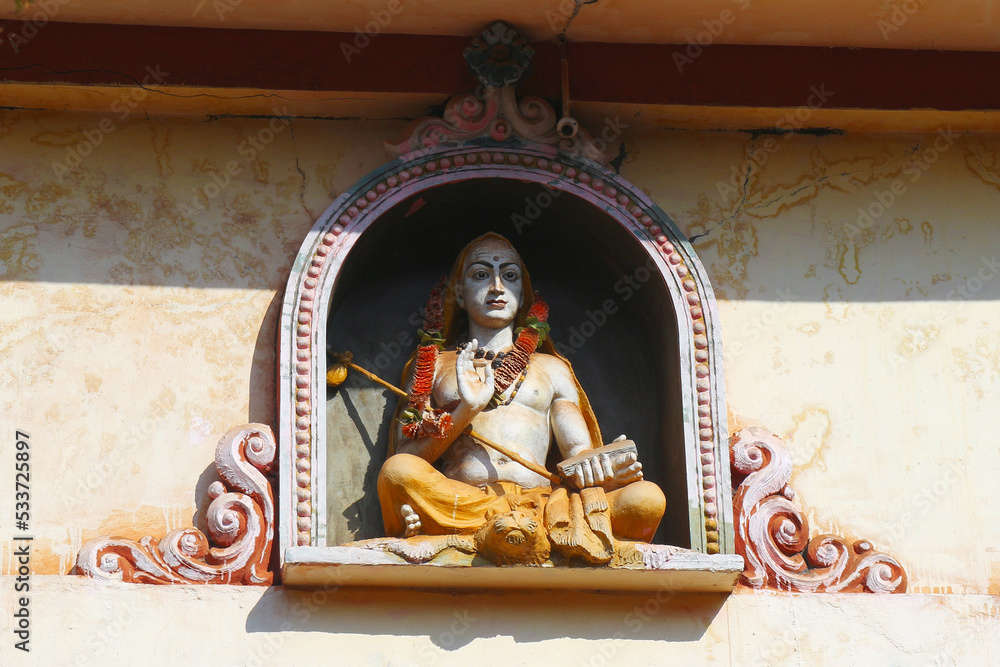 Ramanuja is a Hindu sage in lotus position with a blessing gesture. Religious statue on the temple roof in Gokarna.