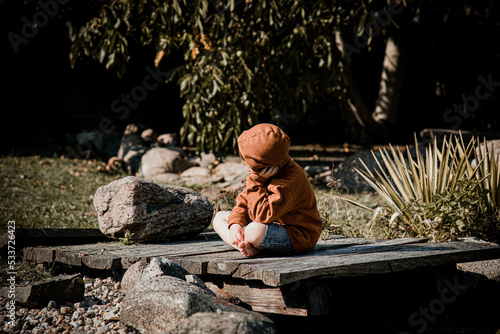 Smutny chłopiec, smutne dziecko w żałobie, wspomina, samotny, zamyślony, zapatrzony, na drewnianym pomoście jesienią © medialne-centrum.pl