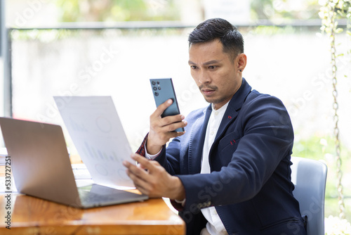 Foto Take picture, Asian Businessman sitting at workplace desk and Taking Photograph