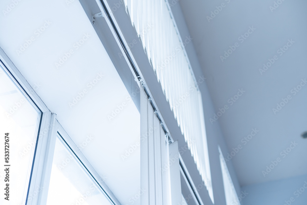 Obraz premium Large window with white roller blinds indoors