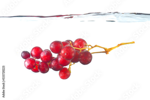 Red grapes in water. Grapes in water splashes isolated. Red Grapes Splashing Into Water on white blackground