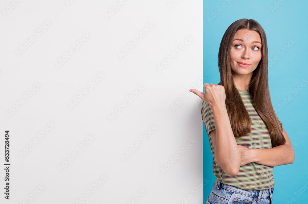 Portrait of positive lovely girl with straight hair dressed striped t-shirt indicating look empty space isolated on blue color background Portrait of positive lovely girl with straight hair dressed striped t-shirt indicating look empty space isolated on blue color background