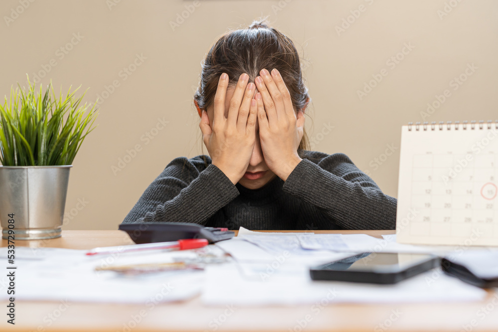 Financial owe asian woman sitting cover face with hands, stressed by calculate expense from invoice or bill, have no money to pay, mortgage or loan. Debt, bankruptcy or bankrupt concept. Financial owe asian woman sitting cover face with hands, stressed by calculate expense from invoice or bill, have no money to pay, mortgage or loan. Debt, bankruptcy or bankrupt concept.