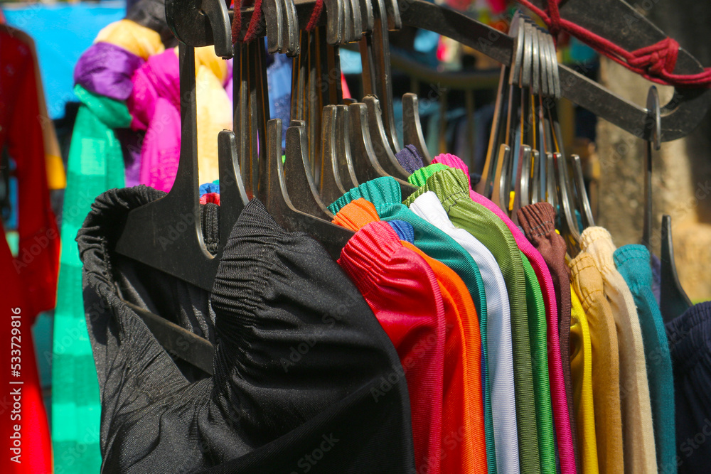 Multicolored women's clothing on hangers is sold in an Indian clothing