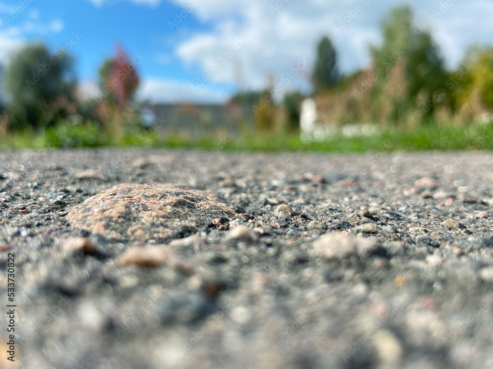 Asphalt background close-up, blurred blue sky with clouds. Asphalt background close-up, blurred blue sky with clouds.