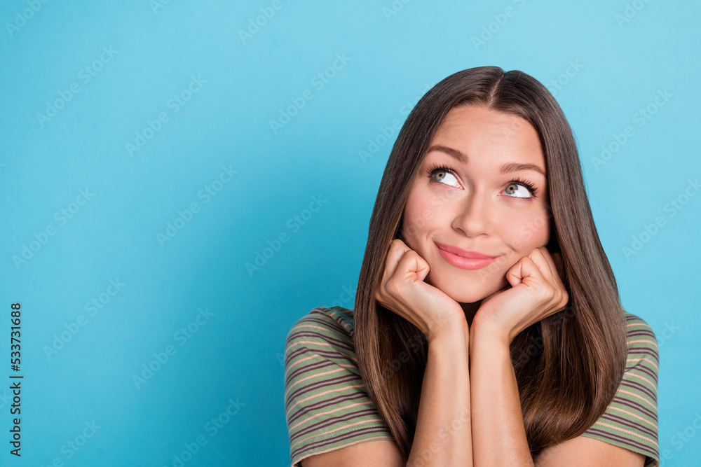 Closeup photo of young cute girlish lady wear striped khaki t-shirt touch cheeks dreamy look interested empty space ad isolated on blue color background Closeup photo of young cute girlish lady wear striped khaki t-shirt touch cheeks dreamy look interested empty space ad isolated on blue color background