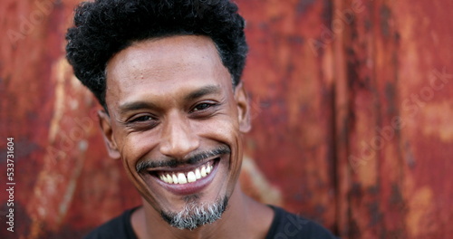 Portrait of mixed race man smiling to camera. Friendly happy african american descent person face outdoors