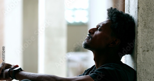 Pensive black man sitting on floor during hard difficult times