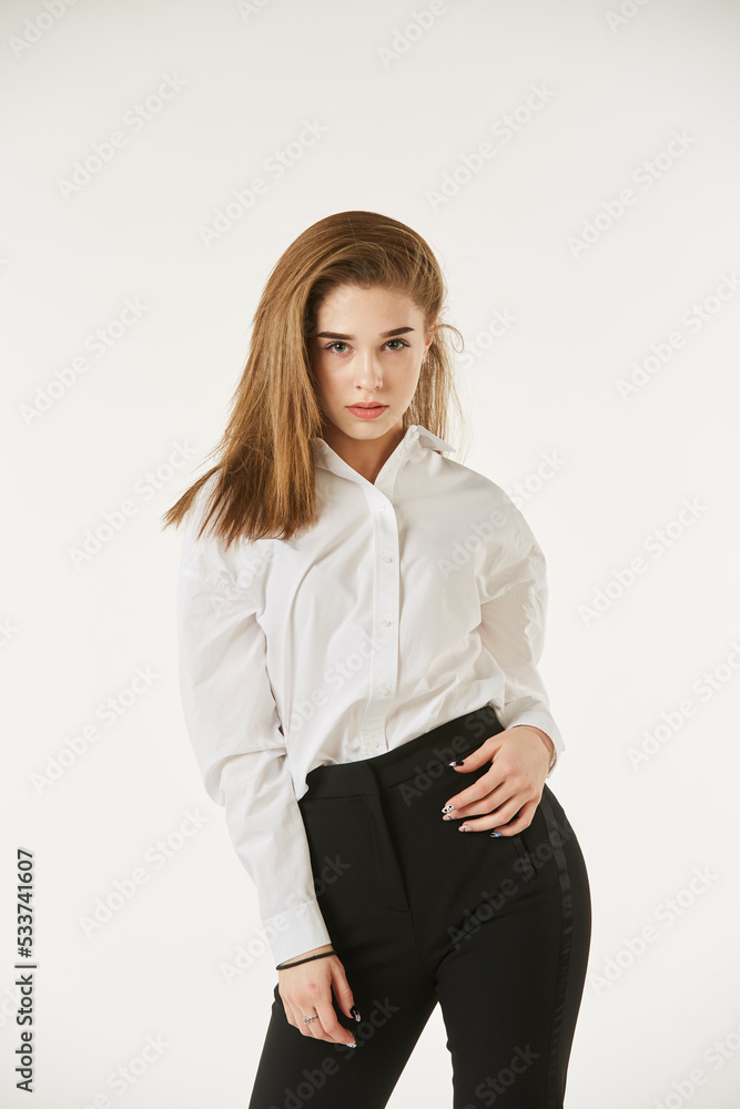 A girl in a white shirt stands on a white isolated background. A girl in a white shirt stands on a white isolated background.