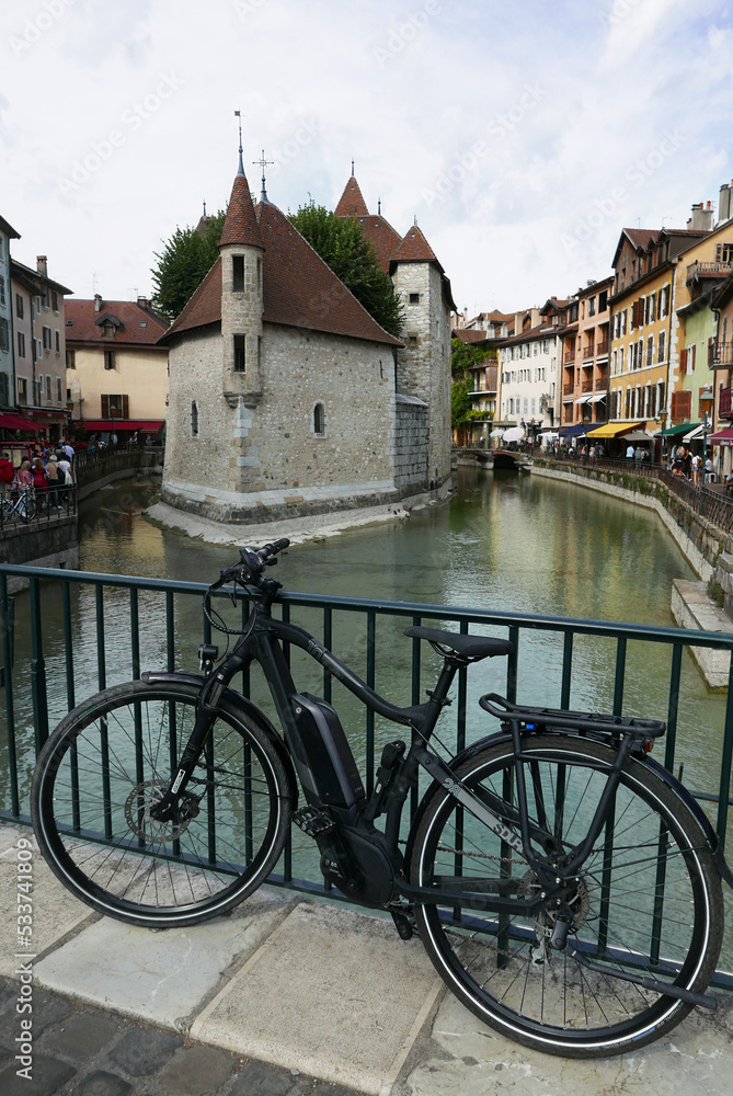 Annecy, vélo électrique sur fond des vieilles prisons le palais de l'ile
