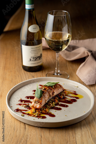 Salmon with vegetable saute. Served with fried pistachios and teriyaki sauce.