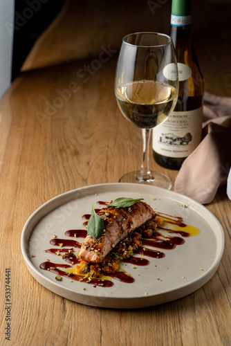 Salmon with vegetable saute. Served with fried pistachios and teriyaki sauce.