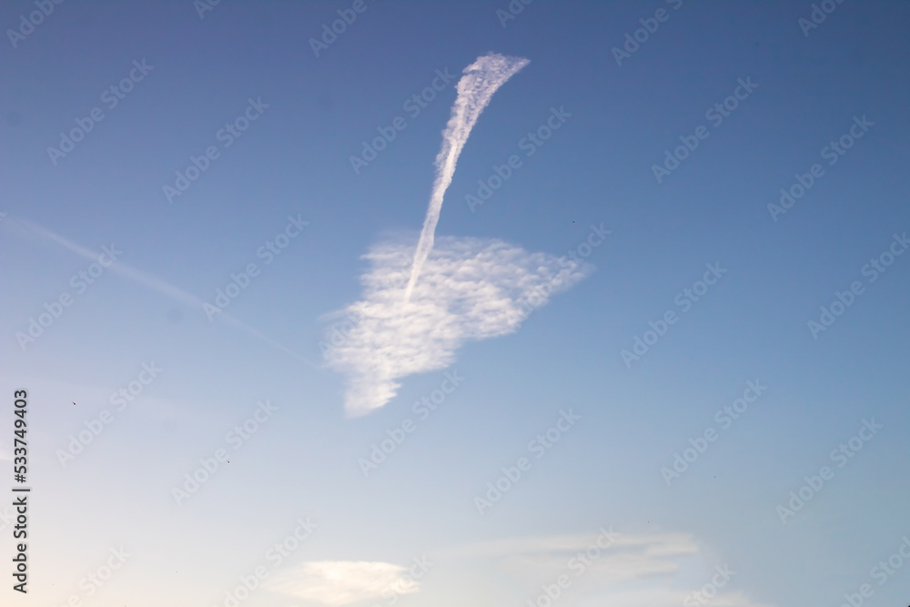 Extraordinary union of cloud to form a perfect arrow on a background of clear blue sky