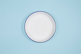 white plate in the center, top view, copy space. On a blue background