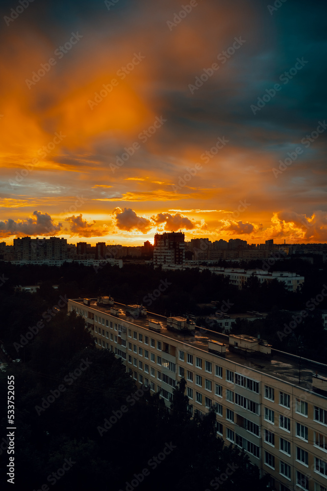 Beautiful sunset in a residential area in St. Petersburg high above the buildings, Russia. Red and orange evening sky in the city
