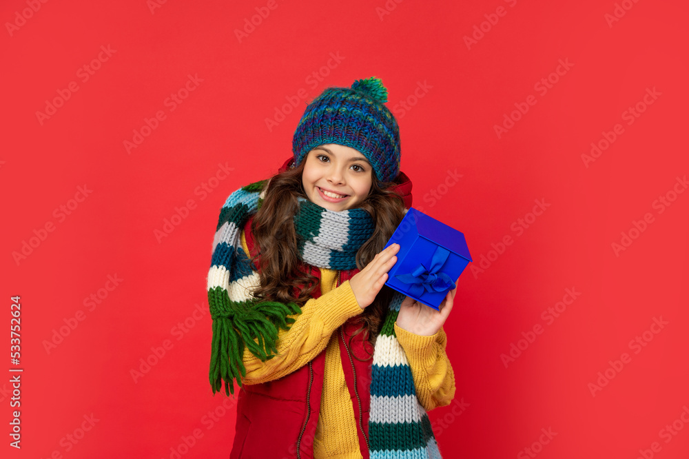 cheerful child in winter clothes hold box on red background, boxing day cheerful child in winter clothes hold box on red background, boxing day