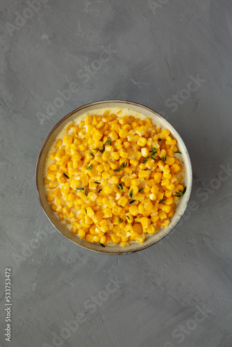 Homemade Slow Cooker Creamed Corn in a Bowl on a gray background, top view. Flat lay, overhead, from above.