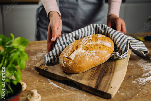 woman holding fresh home made baked bread in her kitchen