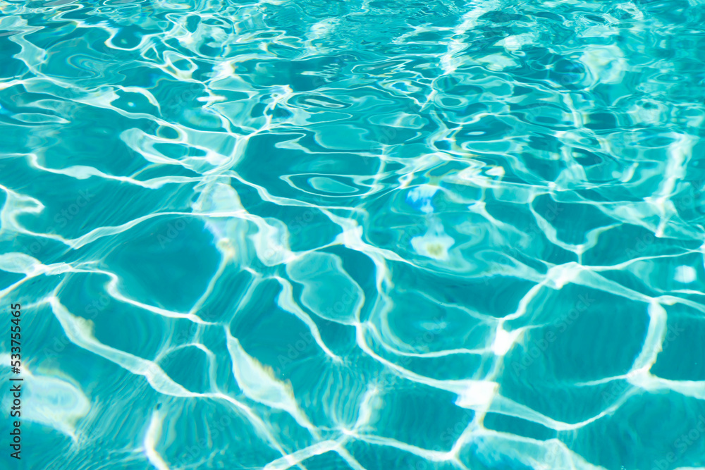 blue color background of swimming pool water with ripples in summertime