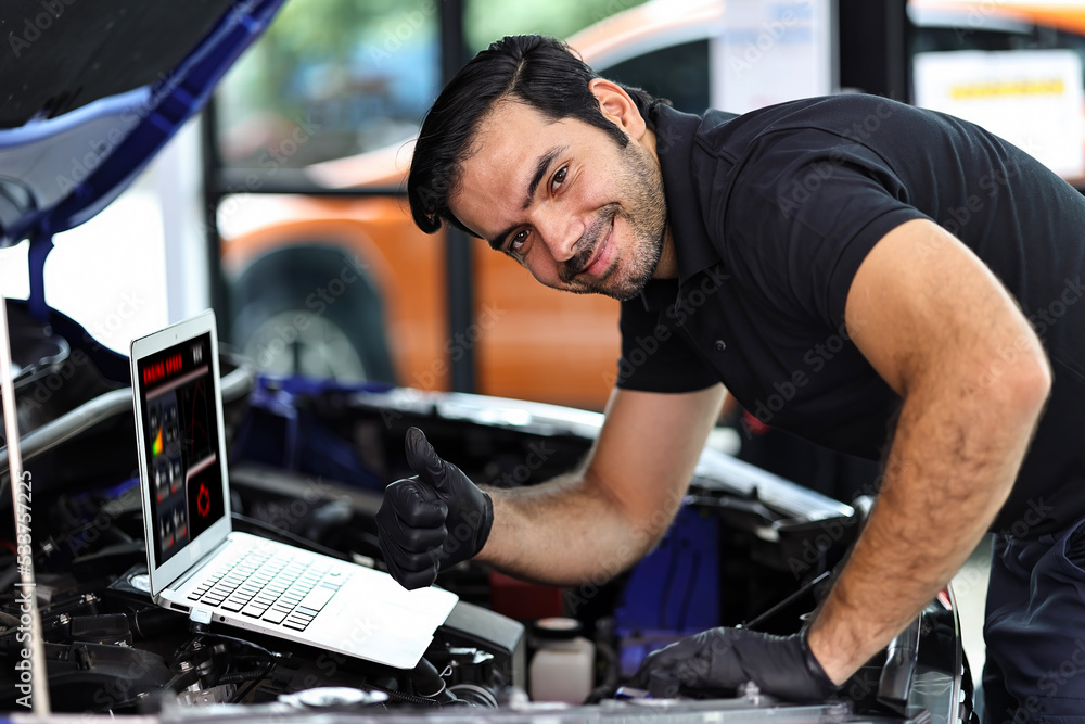 Car mechanic working with a notebook in Auto Repair Service checking car engine. Car mechanic working with a notebook in Auto Repair Service checking car engine.