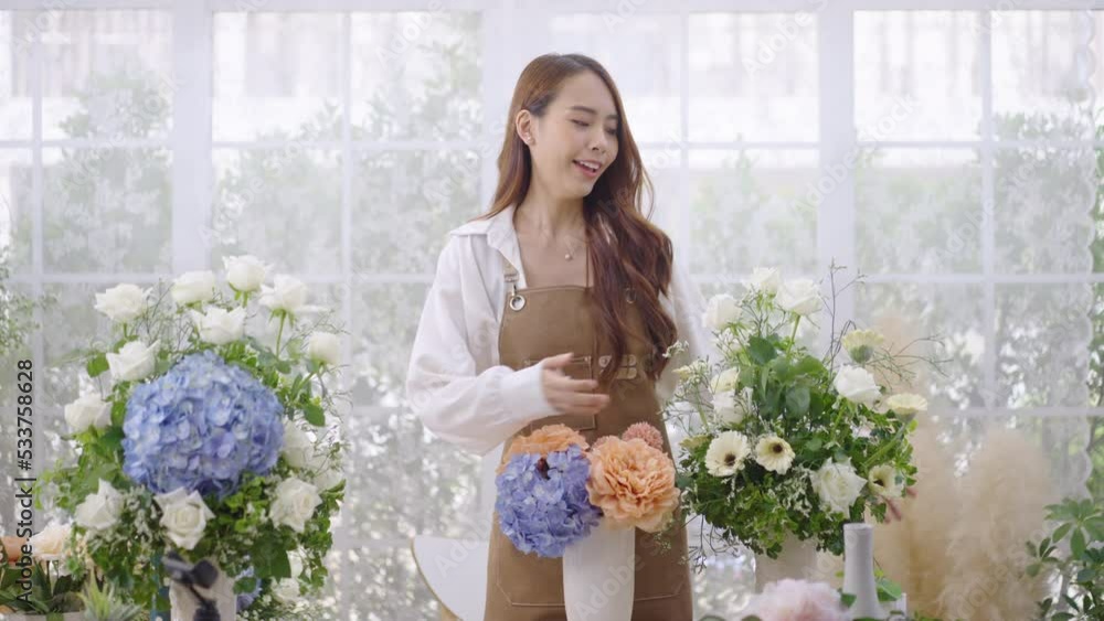 Young Asian woman does a live internet presentation for the sale of her flowers from her house. Young Asian woman does a live internet presentation for the sale of her flowers from her house.