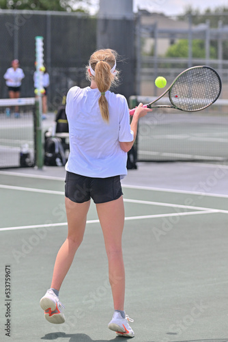 Young girl hitting the tennis ball during a competitive tennis match © Joe