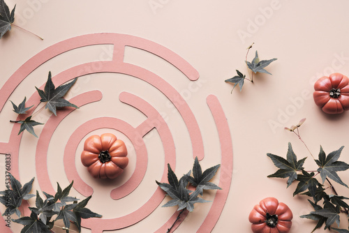 Quadro su tela Autumntime labyrinth background with orange deco mini pumpkins and dull green maple leaves
